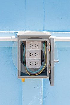 Wrapped White Electric Power Outlet in Gray Cabinet