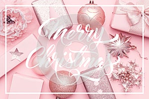 Wrapped xmas boxes, christmas ornaments and baubles. Pink christmas gifts isolated on pastel pink background.