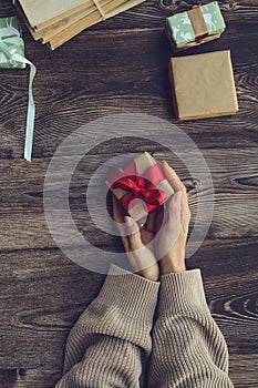 Wrapping small Christmas presents, on brown background