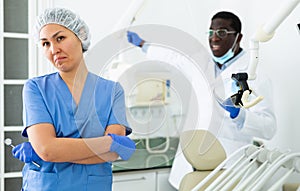 Wrathful man dentist firing sad woman assistant