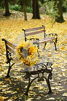 Wreath from autumn leaves on a bench in the park