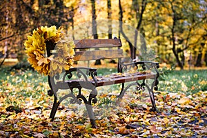 Wreath from autumn leaves on a bench in the park