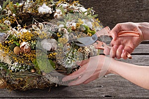 Wreath of dried twigs and flowers on a wooden background. Natural decoration. Celebration concept. Easter wreath. Willow round