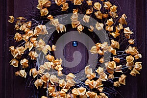 Wreath with dry flowers on the wooden door