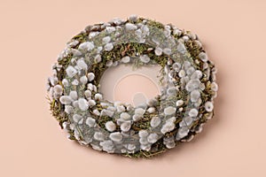 Wreath made of beautiful willow flowers on beige background
