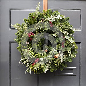 wreath made of pine and juniper, decorated with red berries, artificial birds with orange breast and eucalyptus branches