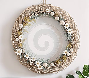 A wreath made of twigs and flowers hanging on a wall.
