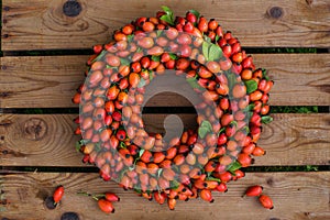 Wreath of rosehips on a wooden background