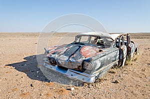 Wreck of classic saloon car abandoned deep in the Namib Desert of Angola photo