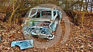 Wreck of old car parked in the forest