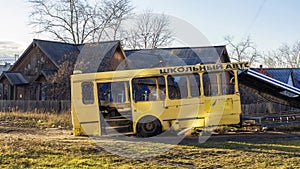 Wreckage bus carcass of yellow school bus in city backyard