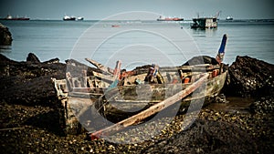 The wreckage of a local fishing boat is stuck in the rocks on the coast of the Gulf