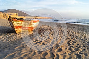 Wreckage of an old boat on the beach by the sea