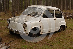 The wreckage of an old car found abandoned in the woods