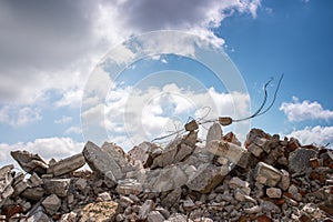 The wreckage of the remains of a building against a blue sky with gray clouds. Background