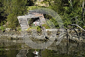 Wrecked boat in a derelict boat house refelection river photo