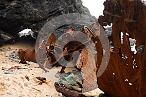 Wrecked pusher boat bow, broken and rusted at the beach photo