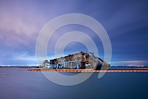 Wrecked ship tanker on a silent sea at night. Long exposure photo.