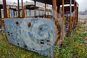 The wrecks of the buses standing on the vehicle cemetery.