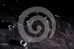 Wrench, bolt, nut isolate on black wood background