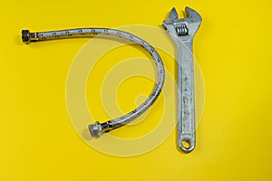 Wrench, drain pipe on a colored background