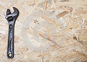 Wrench. Plumber tool on plywood background. Construction industry concept