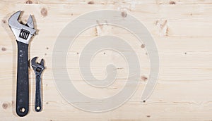 Wrench, small and big one on soft wood background. Construction industry concept