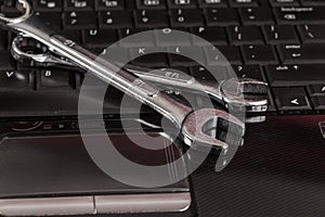 wrench tool and screwdrivers over a laptop