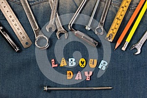 Wrench tools on a denim workers with space for text. Happy Labour Day.