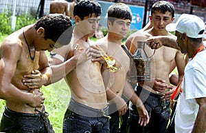 A wrestler has olive oil applied to his body prior to the start of competition at the Kirkpinar Turkish Oil Wrestling Festival, Ed