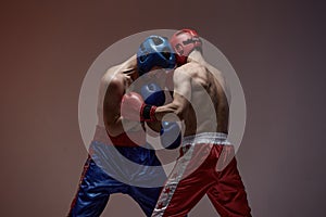 Wrestling of fighting athletic males boxers in studio, martial arts, mixed fight workout