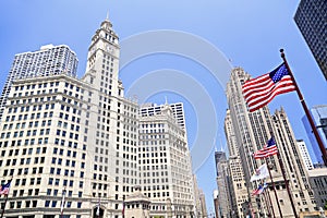 Wrigley Building and Tribune Tower on Michigan Avenue with American flag on the foreground in Chicago