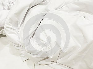 wrinkle messy blanket and white pillow in bedroom after waking up in the morning, from sleeping in a long night, details of duvet