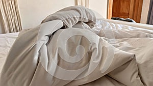 Wrinkled Beige Sheets on Unmade Bed in Cozy Bedroom