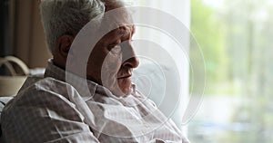 Wrinkled face of hoary senior adult man with sad look