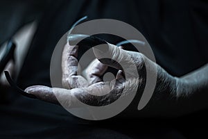 Wrinkled hand with long fingernails