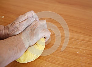 Wrinkled hands making pasta for bread