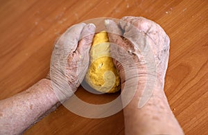 Wrinkled hands making pasta for bread