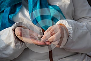 The wrinkled Hands of an old woman sorting through small coins.