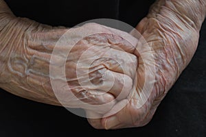 Wrinkled and old grandmother's hands clasped together