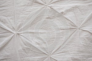 wrinkled white fabric with decorative pinches.