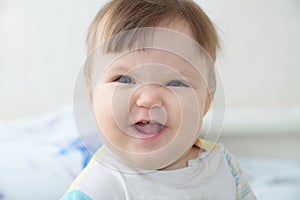 Wrinkling funny infant baby portrait, happy smiling child face expressing emotion photo
