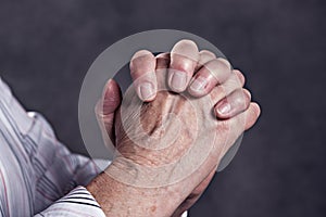 Wrinkly hands of elderly woman praying photo
