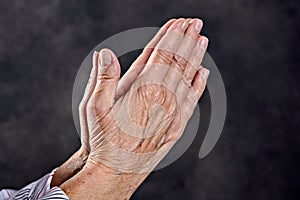 Wrinkly hands of elderly woman praying photo
