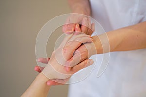 Wrist massage. massage therapist puts pressure on a sensitive point on a woman& x27;s hand. Physiotherapist massaging her