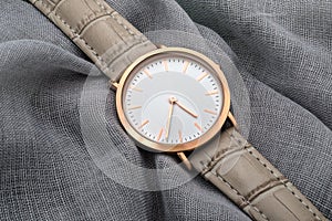 Wrist watch on gray silk fabric background