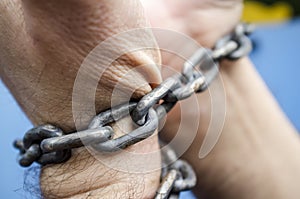 Wrists of the hands are bound with a metal chain. The concept of slavery, imprisonment, lack of freedom photo