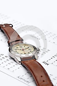 A wristwatch on a calendar