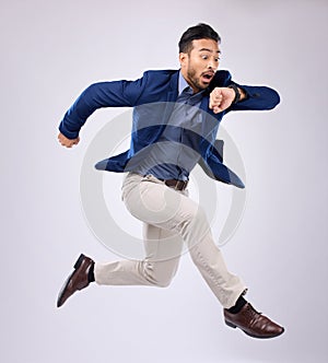 Wristwatch, jump and Asian man late, appointment and employee against a grey studio background. Male manager, consultant