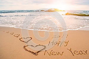 Write 2017 happy new year on beach with hearts